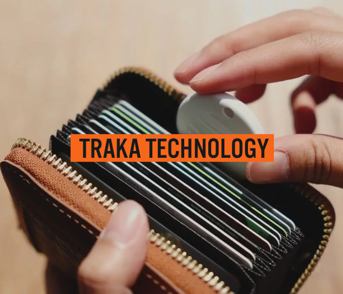 Person holding a wallet with cards and a Travel Traka, with 'Traka Technology' branding.